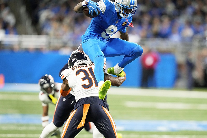 Lions player Williams jumping over Bears player